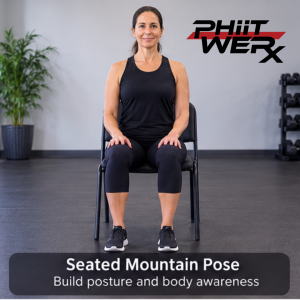 Person sitting tall in a chair with feet grounded while practicing seated mountain pose in a Chair Yoga class.